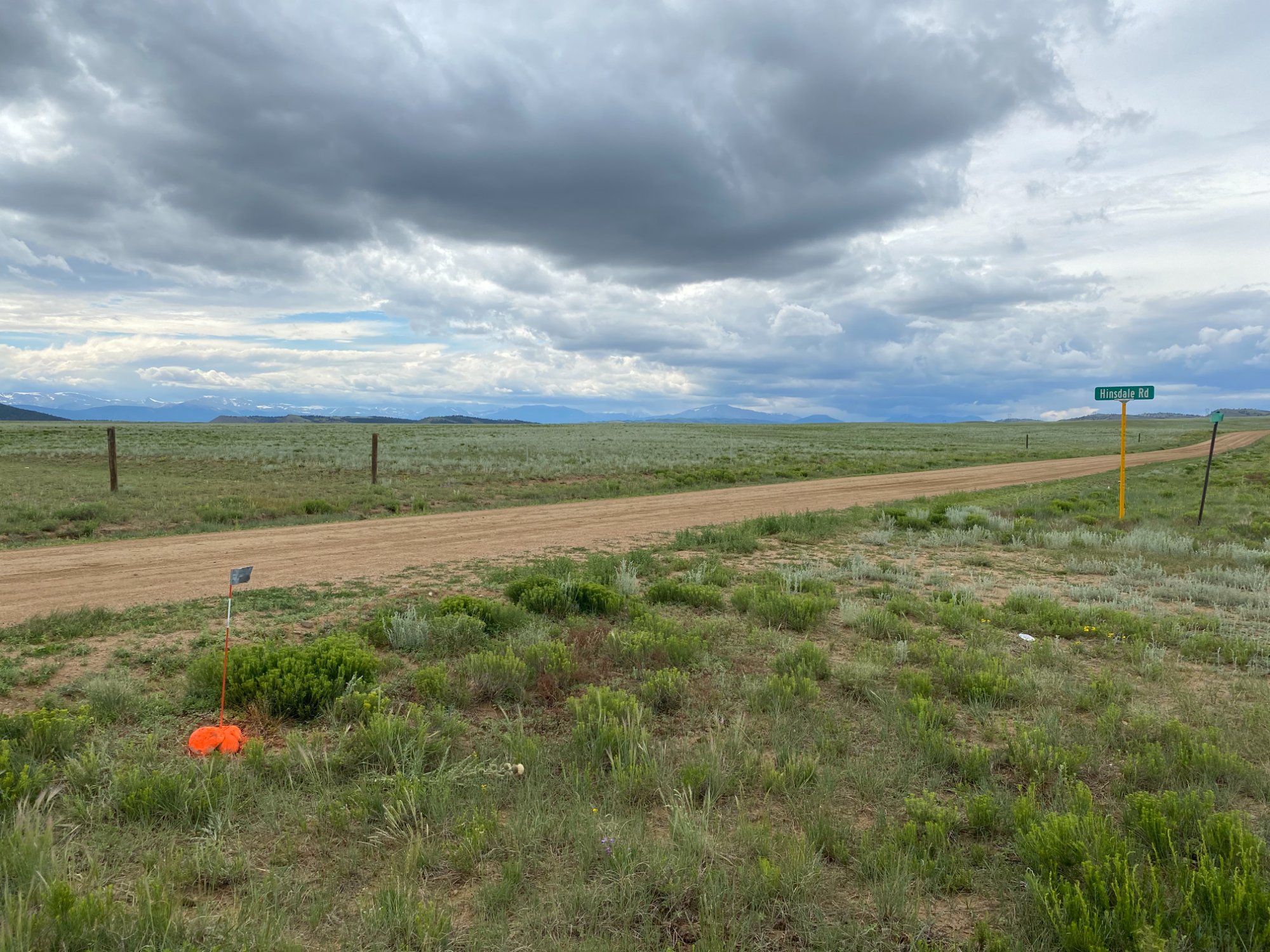 Open Colorado land with dirt road and dramatic skies